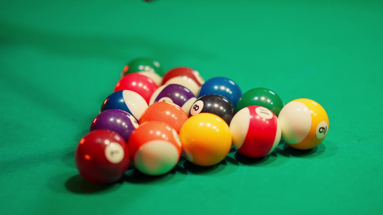 Close-Up of Hands Racking Pool Balls on Green Felt