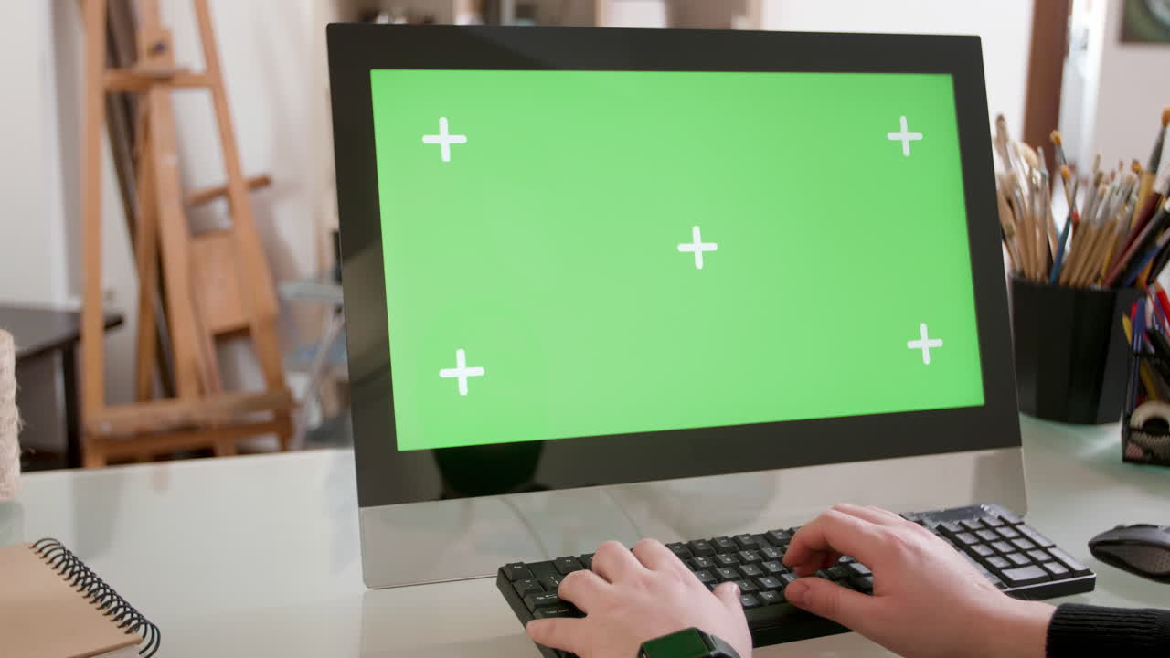 Computer with green screen and art supplies