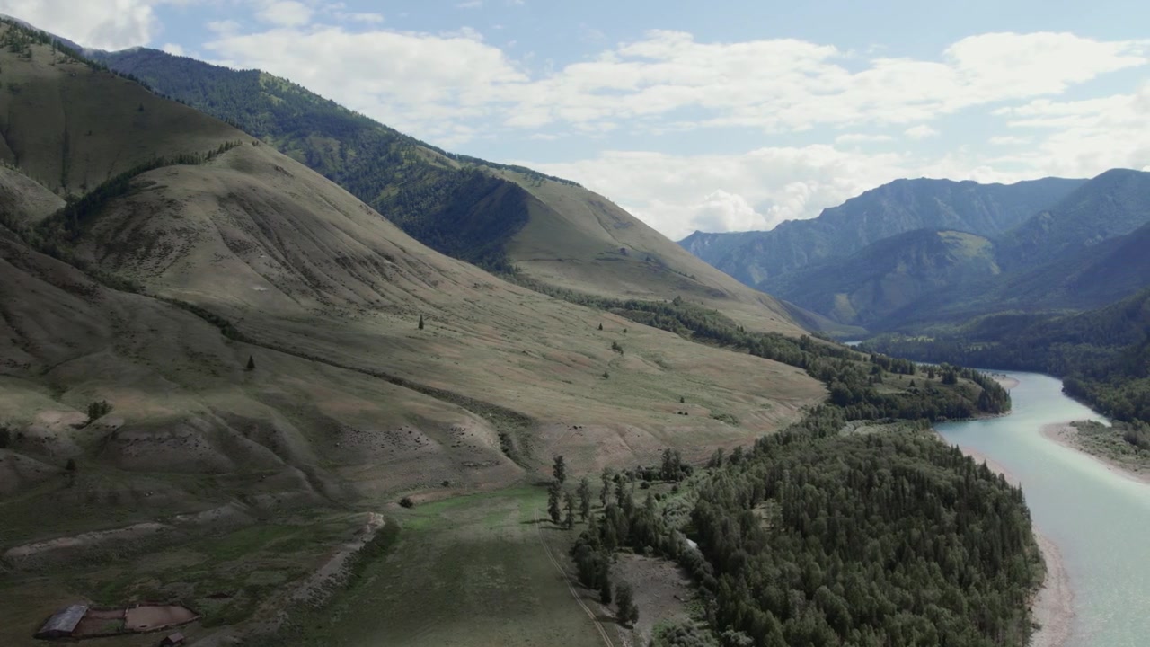 Filmato drone dell'ampia Valle di Ak-Kem con dolci pendii montani, prati verdi, foresta e fiume sotto un cielo nuvoloso, Repubblica dell'Altai, Russia, paesaggio estivo di viaggio.