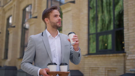 Man-carrying-paper-cups-with-hot-coffee-to-office.-Manager-drinking-tea-on-move