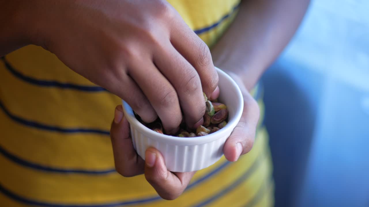Child holding a bowl of pistachios