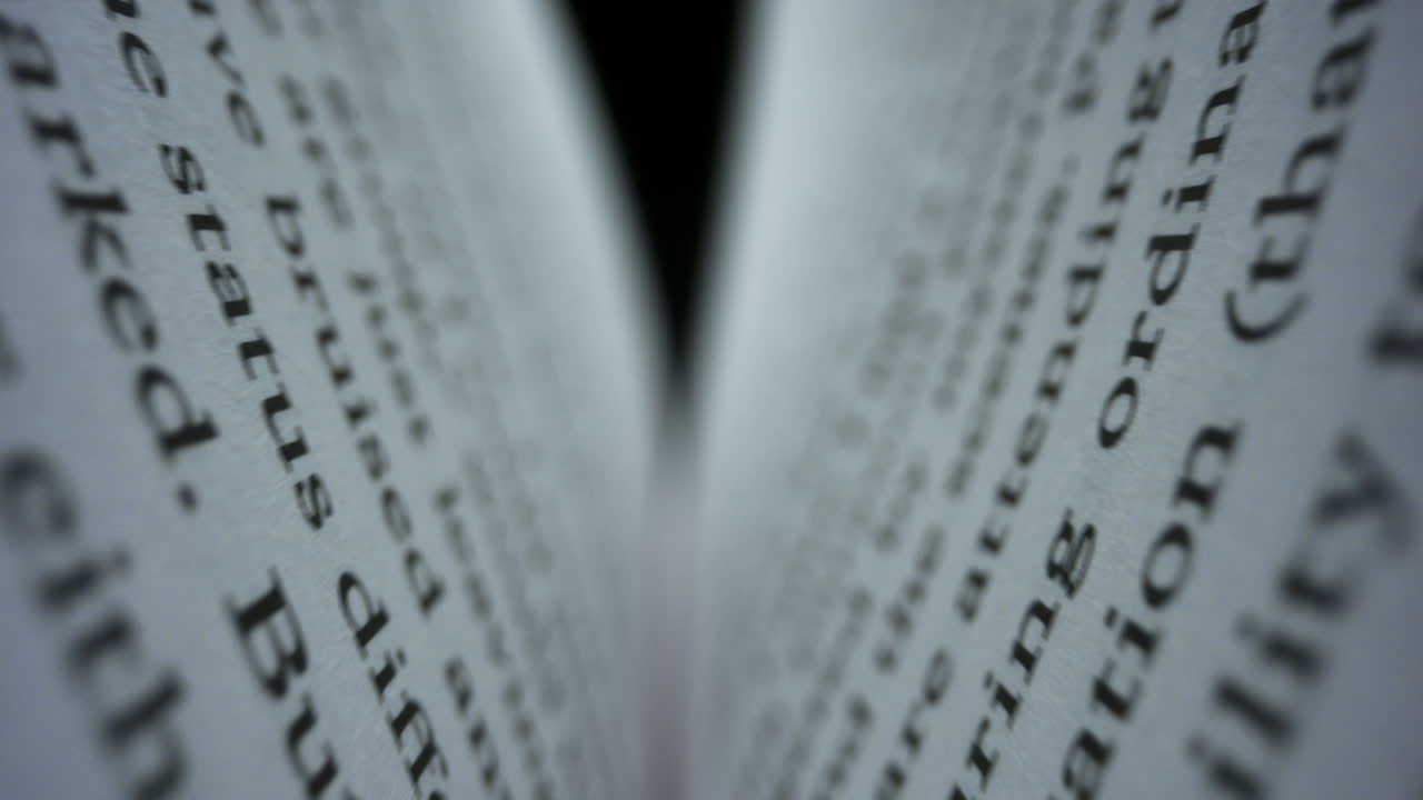 Closeup book sheets with english text. Camera moving between book pages