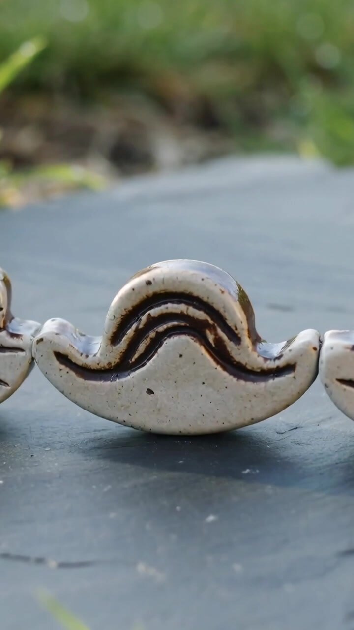 Vertical video: Shifting lens focusing center crescent on garden slate to highlight three tiles