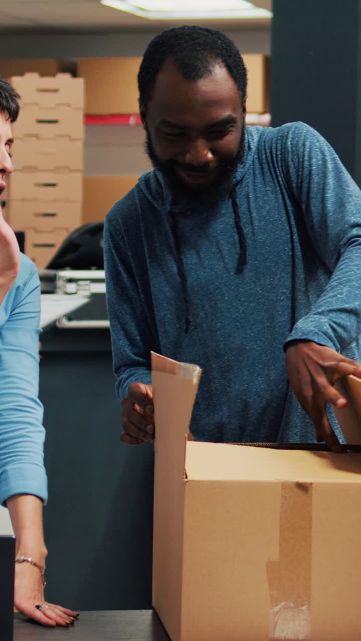 Vertical video: Business owners giving highfive after putting products in cardboard boxes