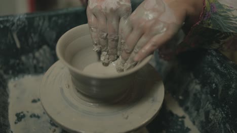 close up of clay pot forming on spinning wheel by hands in pakistan