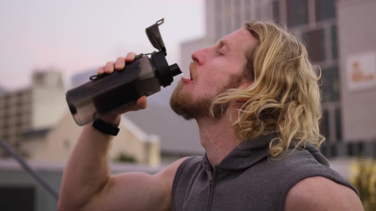 hombre caucásico deportivo bebiendo agua