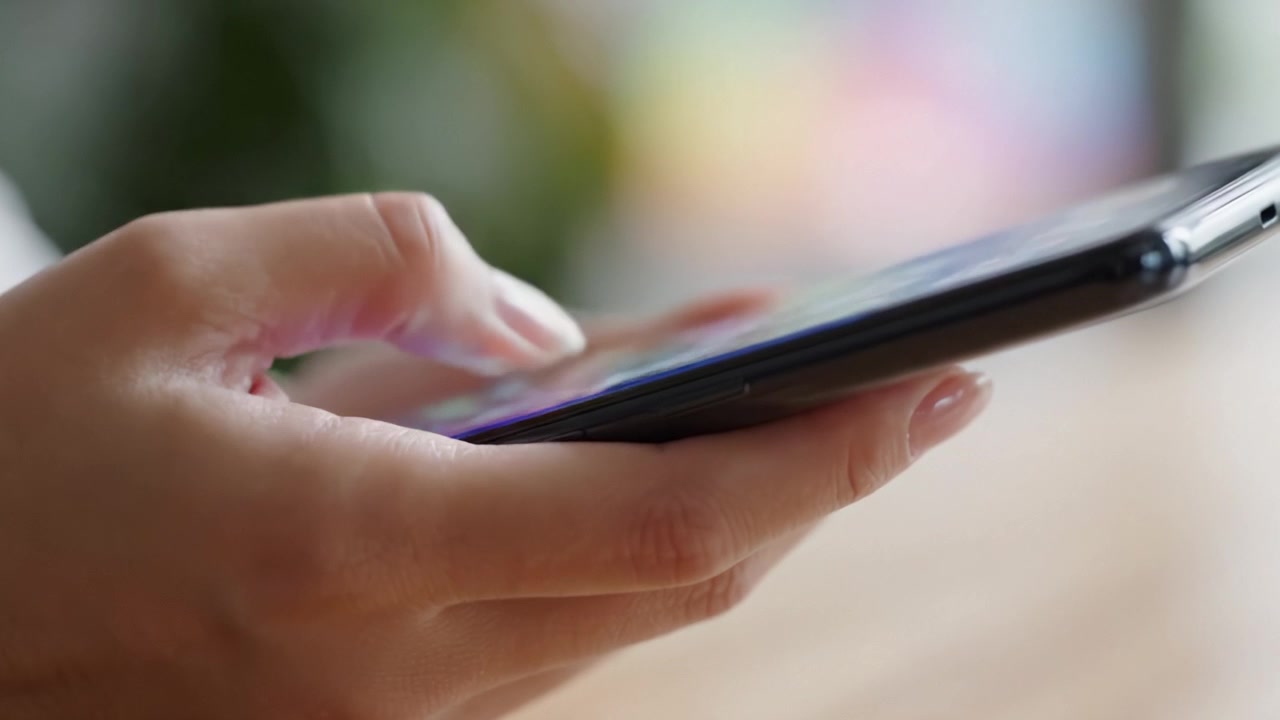 Primo piano di una mano con touchscreen di smartphone, che cattura le complessità dell'uso della tecnologia mobile nella vita quotidiana.