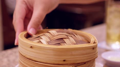 Detail-removing-lid-from-container-for-sautéing-pork-dumplings