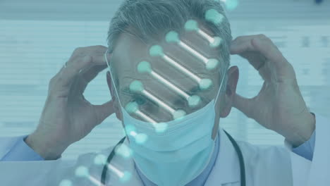 animation of dna structure spinning over caucasian male doctor wearing surgical mask at hospital