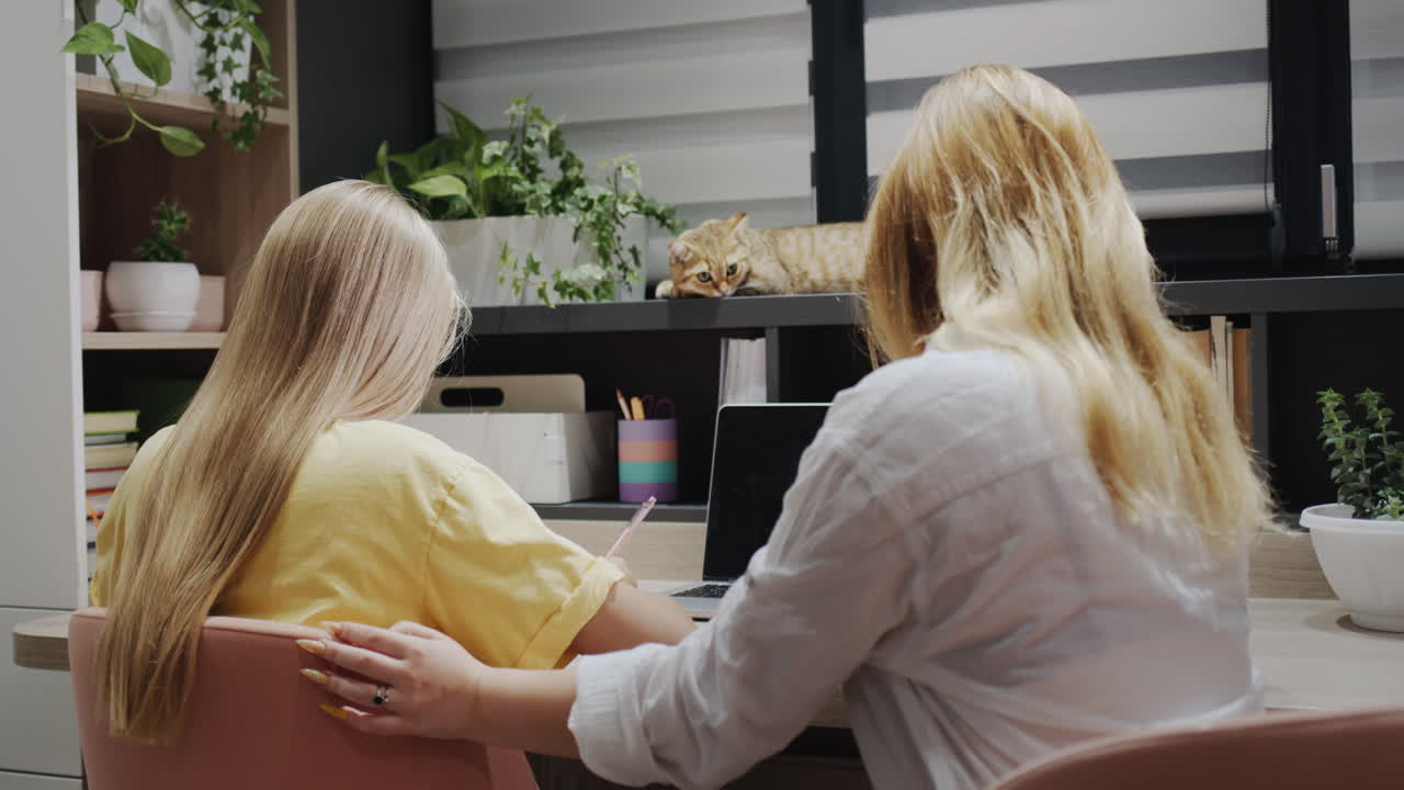 교실 에서 노트북 을 사용 하고 있는 소녀 를 돕는 교사 나 부모