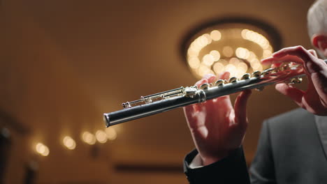 orquesta de bronce en la sala filarmónica flautista está tocando la flauta vista de cerca del instrumento de viento