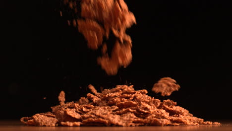 copos de cereal que se derraman sobre un fondo negro
