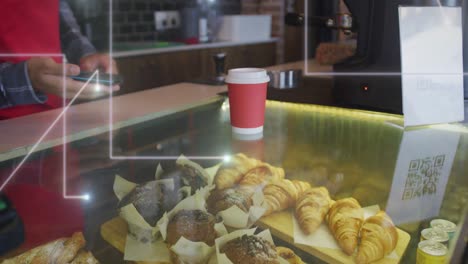 animation of spots of light over man serving coffee working in cafe