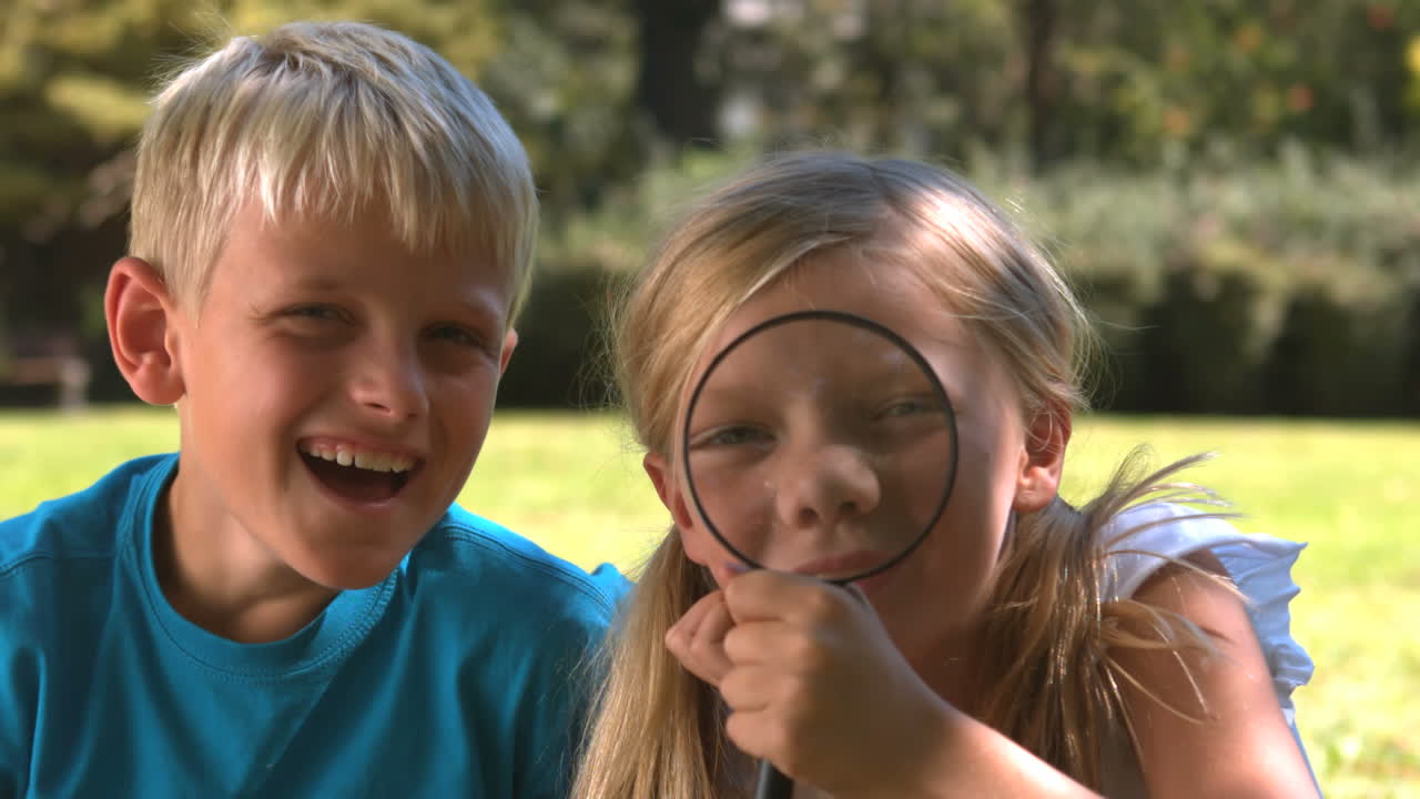 hermana tonta divirtiéndose con una lupa