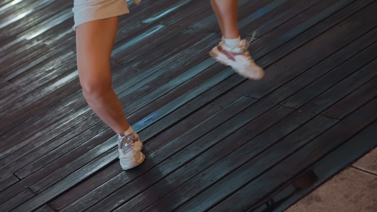 Nighttime footsteps on wet wooden surface. Urban midnight dance with swift footsteps on damp planks. Vivid scene of footwear moving rhythmically on shimmering wet sidewalks after dark