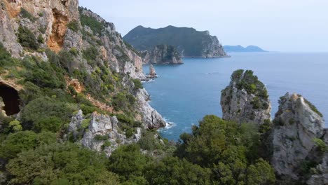 Aerial,-flying-close-over-cliff-revealing-rocky-coastline-on-Corfu,-Greece,-slow-motion