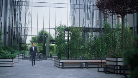 Hombre-De-Negocios-Confiado-Caminando-Solo-En-El-Jardín-Del-Centro-De-Negocios.-Lugar-De-Recreación.