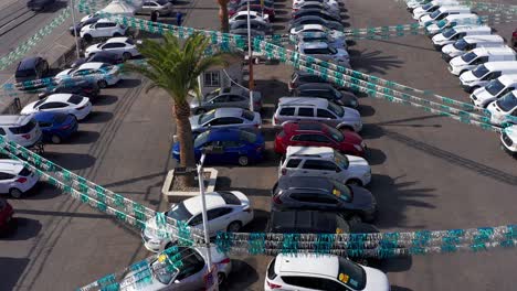 aerial flyover shot above a used car dealership lot