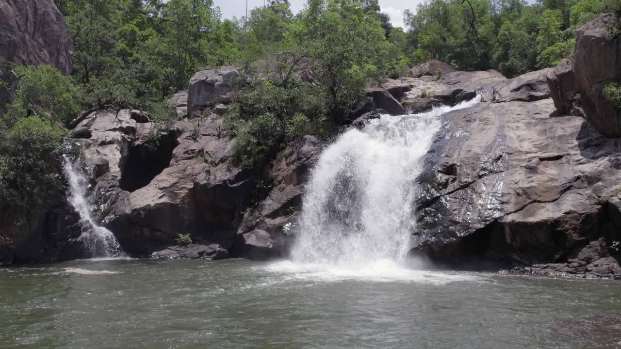 Waterfall cascades down bare rock into misty pool, Nora Falls, RSA