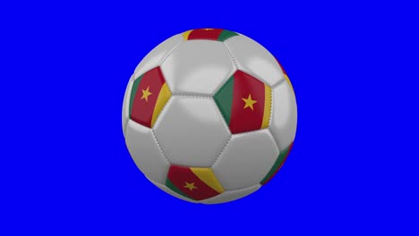 pelota de fútbol con bandera de camerún en fondo de clave de croma azul, bucle