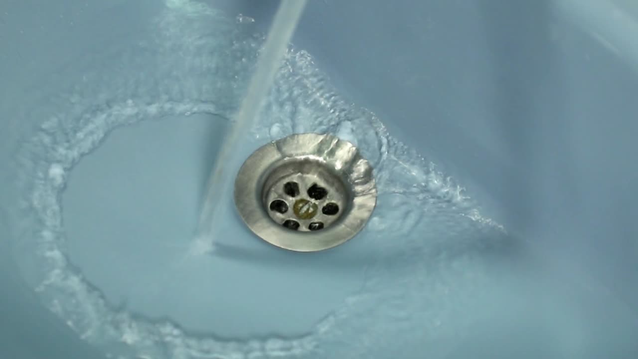 agua fresca y clara cayendo por el desagüe del baño