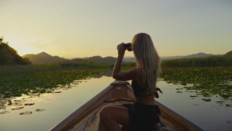 a woman on a boat at skadar lake, montenegro, enjoying the sunset and nature