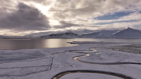 a revelatory aerial view captures the majestic winter landscape of borgarfjörður, iceland, with the snow-capped peaks of hafnarfjall, kessuhorn, and the distinctive baula mountain on the horizon.