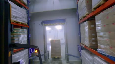 FPV-drone-view-of-forklifts-moving-frozen-food-cargo-in-huge-warehouse