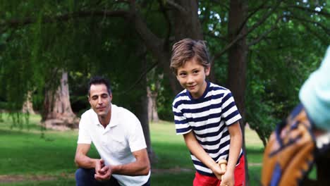 family playing baseball in the park