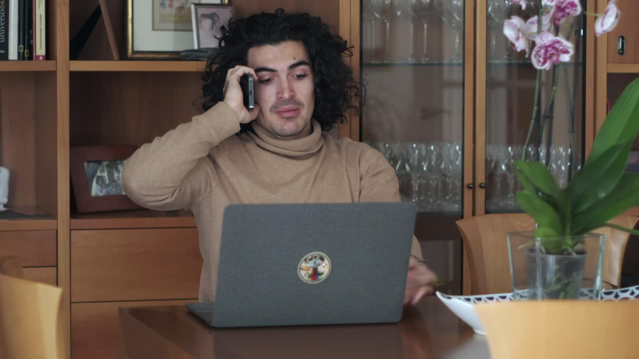 Multi-Tasking Pro: Man Juggles Laptop and Phone Call with Ease