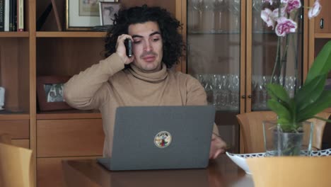 profesional multitarea: el hombre hace malabarismos con la computadora portátil y la llamada telefónica con facilidad