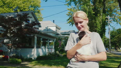 woman holds a puppy while walking