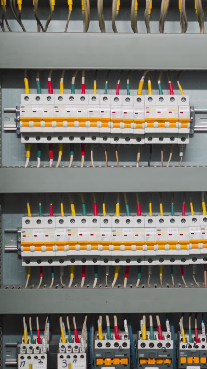 Rows of breakers and colorful wires on open circuit board. Switchboard with tools for automatic interruption of electrical current short circuit flow at station