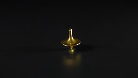 golden top spinning on a black surface