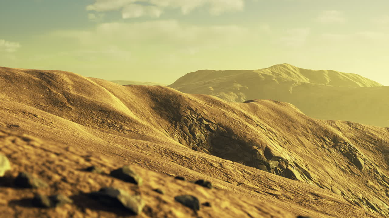 Golden hills stretch across a vast landscape under bright sunlight