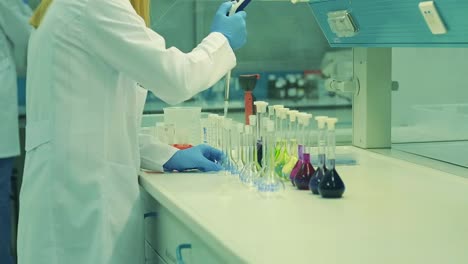 measurement is done in the laboratory. the received liquid substance is mixed with beaker. woman is preparing mixture in the laboratory. danger