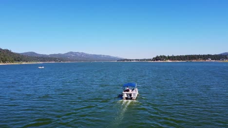 revelación aérea de un barco de alquiler en el lago big bear en el bosque nacional san bernardino de california con cielo azul y montañas en el fondo