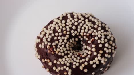 chocolate donut on a white background. the donut is sprinkled with white powder. view from above