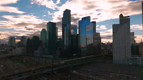an aerial view of long island city, ny with skyscrapers in queens. taken during a cloudy evening over the sunnyside yard and facility. the camera is stationary.
