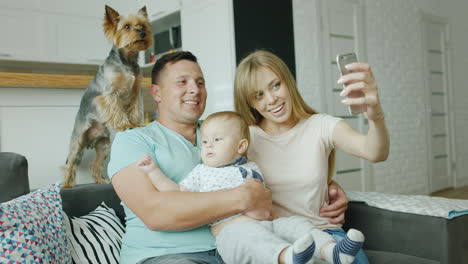 a young couple makes a selfie along with her baby boy