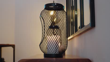 slow revealing shot of candles burning on a table with a lamp in the corner