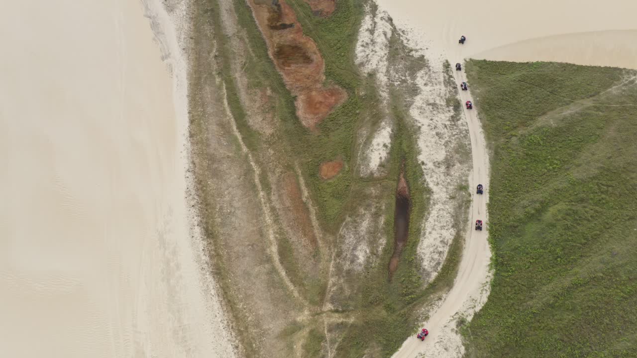 línea de seguimiento de drones de turistas en vehículos todo terreno en el camino a través de las dunas de arena brasileñas