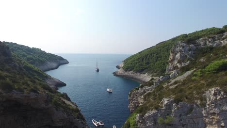 ascending aerial view of a secluded cove protected and hidden by steep rocky hillsides