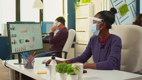 african workers with face mask writing on pc and looking on camera