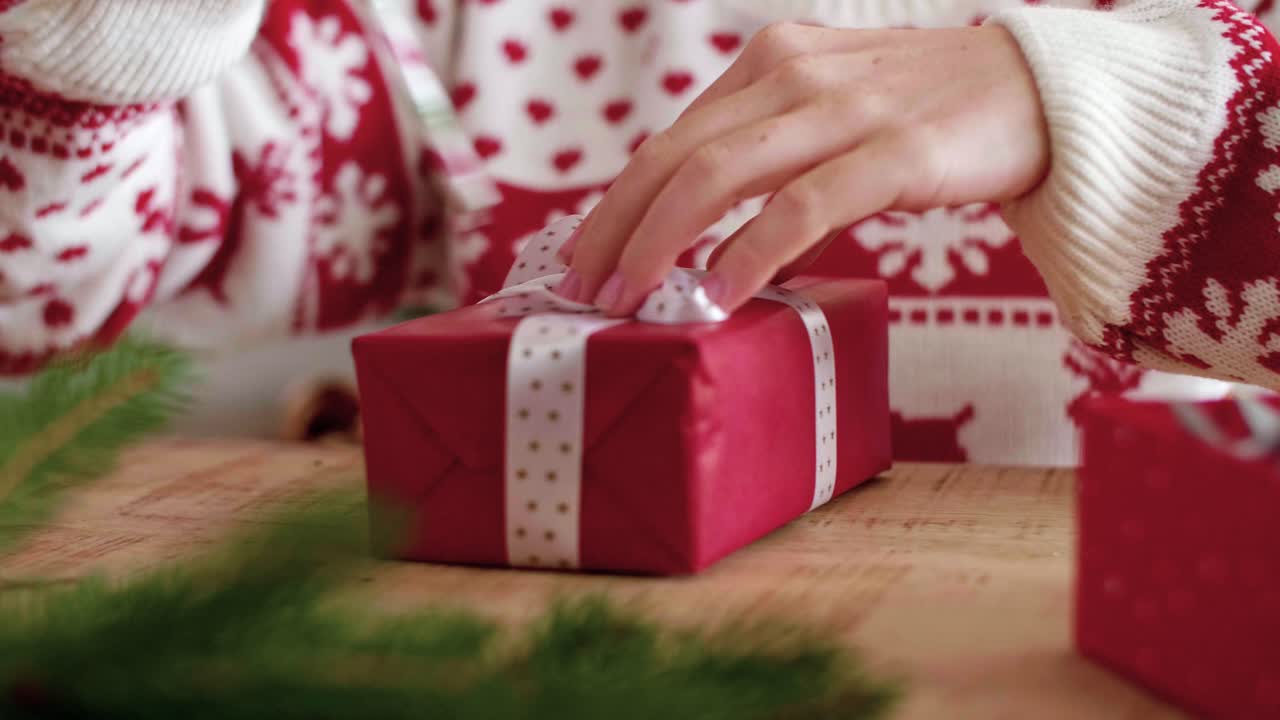 Close up of girl's hands decorating the christmas present