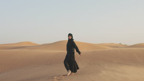 sígueme foto de una hermosa mujer musulmana con hiyab caminando descalza en un desierto ventoso 1