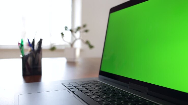 Laptop mit Greenscreen auf einem Schreibtisch zu Hause