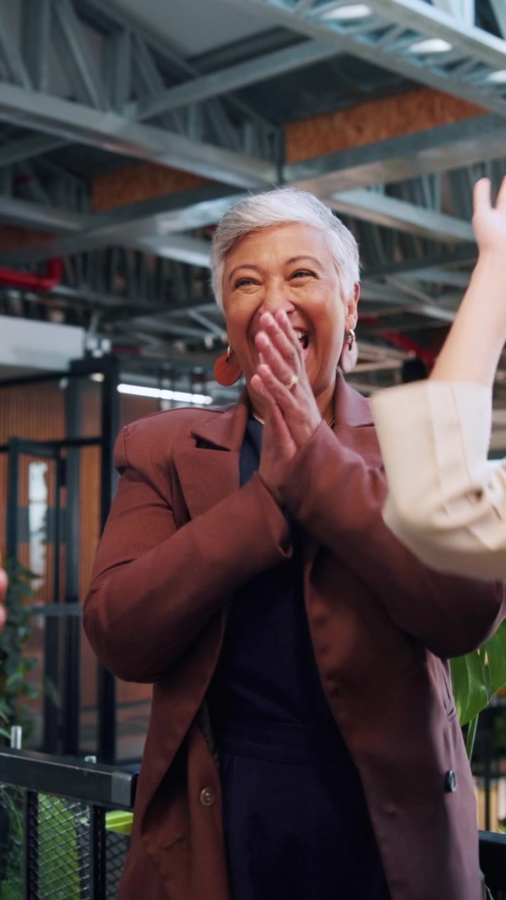Happy Senior Businesswoman Celebrating Success with Colleagues in Office
