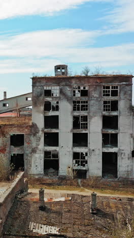 aerial view of an old factory ruin and broken windows. old industrial building for demolition. vertical video