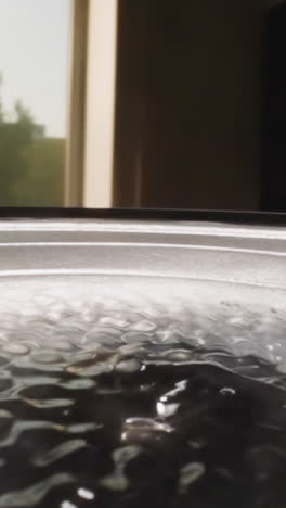 slippery hyaluronic acid shaking and bouncing on loud speaker reflecting bright light. sound equipment playing while liquid substance vibrating macro